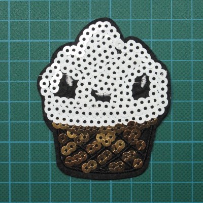 Embelezamento em forma de gelado feito de lantejoulas sobre base de corte verde