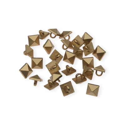 Tachas metálicas douradas em forma de pirâmide quadrada sobre fundo branco