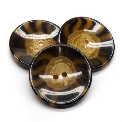 Três botões redondos castanho e preto com padrão marmoreado