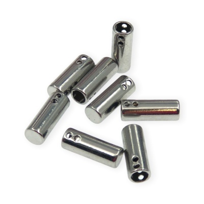 Peças metálicas cilíndricas prateadas com orifícios, sobre fundo branco