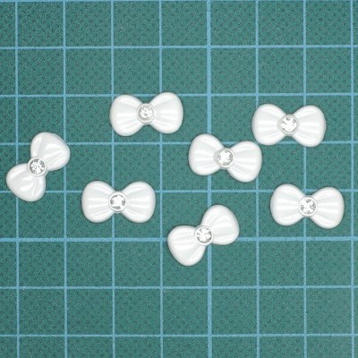 Sete botões brancos em forma de laço sobre fundo quadriculado verde