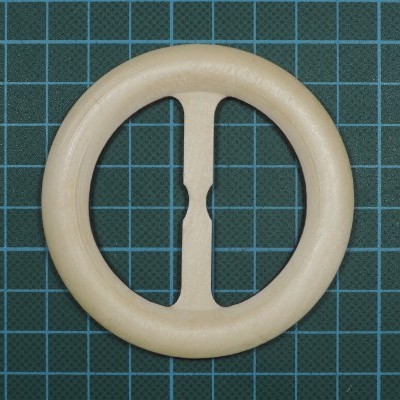 Fivela circular de madeira clara sobre superfície quadriculada verde escura