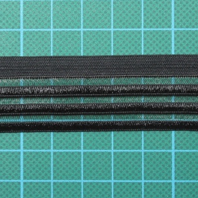 Cinco palitos pretos alinhados sobre tabuleiro de corte verde quadriculado