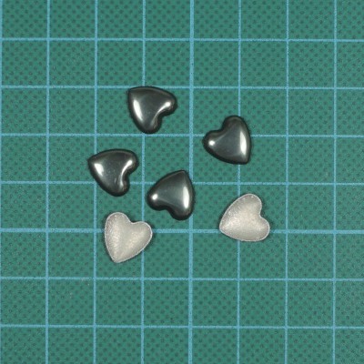 Cinco pequenos corações em cinzento metálico e bege sobre base verde quadriculada