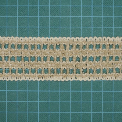 Faixa de renda bege com padrão quadriculado sobre uma superfície verde de corte