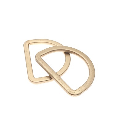 Dois anéis metálicos dourados, um retangular arredondado e outro em meia-lua