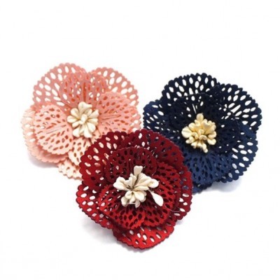 Três flores decorativas de tecido rendado em rosa, azul e vermelho