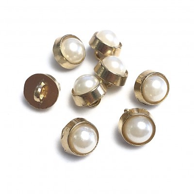 Botões dourados com pérola branca no centro sobre fundo branco