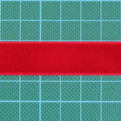 Fita vermelha de veludo sobre superfície verde quadriculada