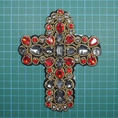 Broche em forma de cruz com pedras vermelhas e cinzentas em moldura dourada