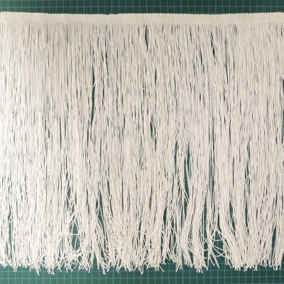 Franjas brancas de tecido sobre superfície verde de corte com grelha