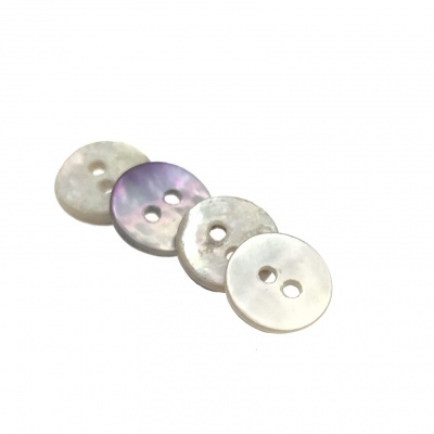 Quatro botões redondos perolados e lilás com duas e uma furações.
