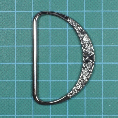 Fivela metálica em forma de D com padrão floral prateado