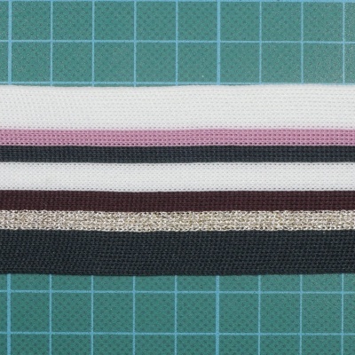 Tiras de tecido listrado de cores variadas sobre superfície quadriculada verde