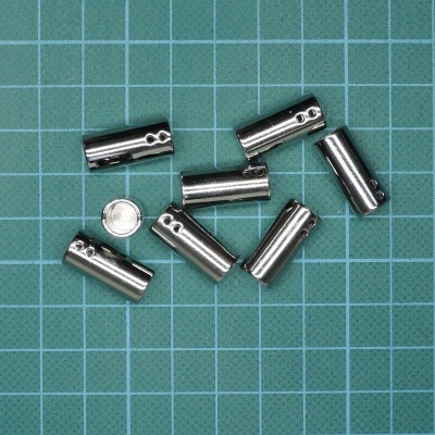 Set de pilhas pequenas prateadas sobre superfície verde quadriculada