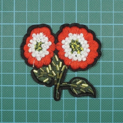 Aplicação de tecido flores vermelhas e brancas com pérolas e detalhes dourados