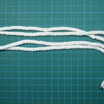 Corda branca trançada sobre superfície verde com grelha