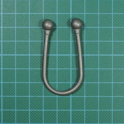 Suporte em metal prateado em forma de U com extremidades arredondadas sobre fundo verde quadriculado