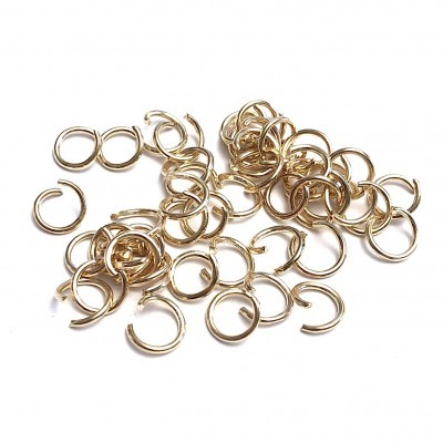 Argolas de metal dourado abertas sobre fundo branco