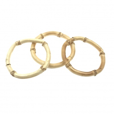 Três pulseiras redondas de bambu em diferentes tons sobre fundo branco