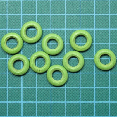 Argolas verdes de plástico sobre superfície com grelha azul e branca