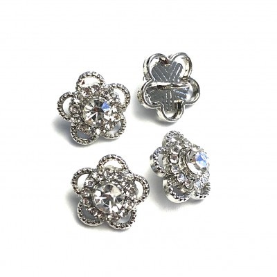 Botões florais prateados com pedras brilhantes sobre fundo branco