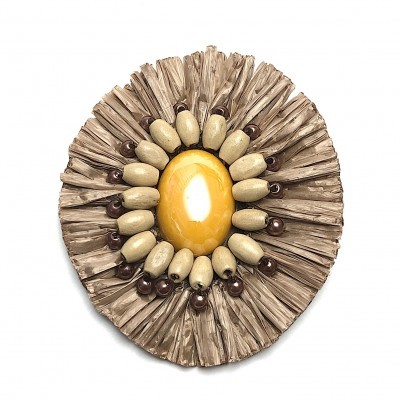 Broche redondo com pedra amarela e contas castanhas sobre fundo branco