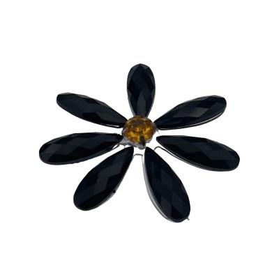 Flor decorativa preta com centro amarelo sobre fundo branco