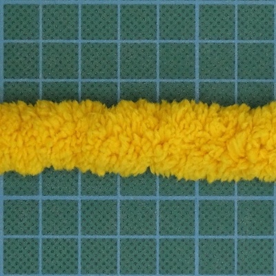 Faixa felpuda amarela sobre fundo verde quadriculado