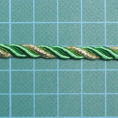 Cordão torcido em fios verde, verde claro e branco sobre superfície quadriculada azul