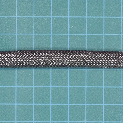 Cabo metálico prateado com malha trançada sobre superfície verde quadriculada