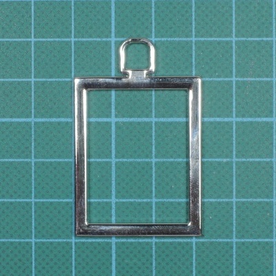 Argola quadrada prateada sobre fundo verde quadriculado