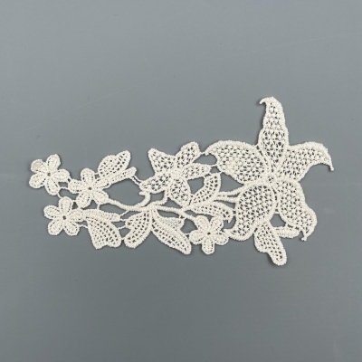 Aplicação de renda branca floral sobre fundo cinza