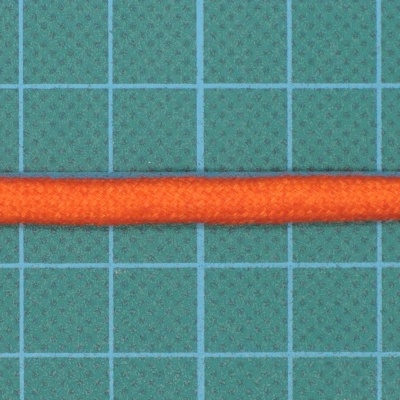Cabo ou fio laranja sobre superfície quadriculada verde.