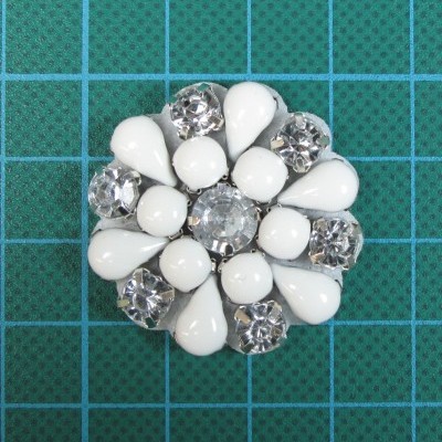 Botão decorativo branco e transparente em fundo de grade verde