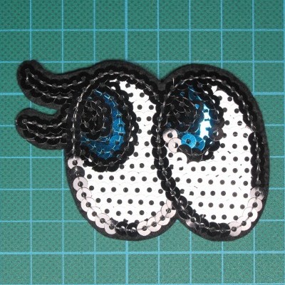 Patch olhos cartoon paetês sobre fundo verde de corte