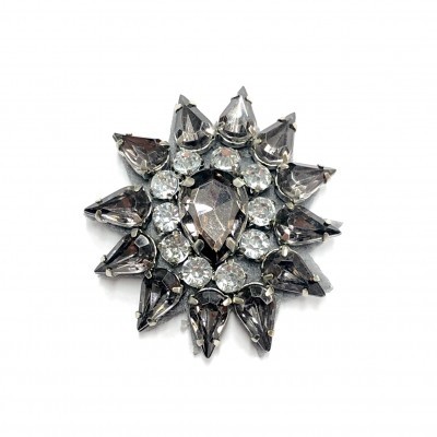 Broche estrela com pedras cinza fumado e transparentes em suporte metálico prateado