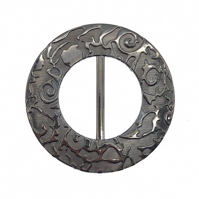 Fecho circular metálico com padrão gravado e barra central.