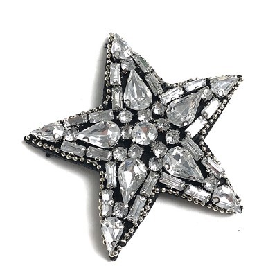 Broche estrela com pedras transparentes em fundo branco