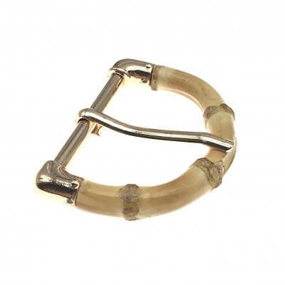 Fivela em formato de D com detalhes que imitam bambu em tons bege e marrom claro.