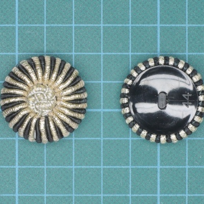 Par de botões redondos dourados e brancos sobre superfície quadriculada azul