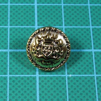 Botão dourado redondo com brasão e relevo em fundo verde quadriculado