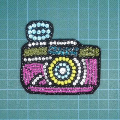 Aplicação colorida em contas de máquina fotográfica sobre fundo quadriculado azul