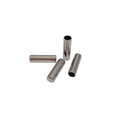 Quatro tubos metálicos cilíndricos prateados sobre fundo branco.