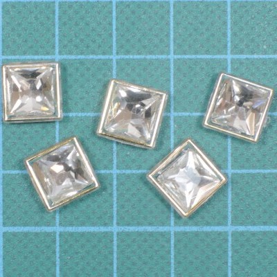 Cinco botões quadrados transparentes com moldura prateada sobre superfície azul quadriculada
