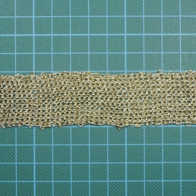 Fita de tecido bege com textura sobre fundo quadriculado verde