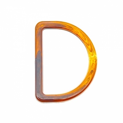 Letra D em resina acrílica âmbar e castanha sobre fundo branco