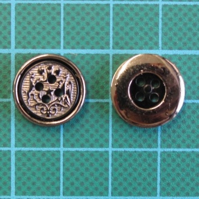 Dois botões metálicos redondos sobre fundo quadriculado verde e azul