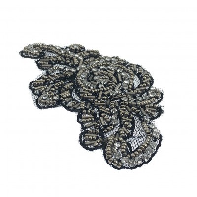 Aplicação decorativa bordada com miçangas e lantejoulas prateadas em padrão floral sobre tule preto