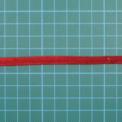 Fita vermelha estreita sobre fundo de grade verde